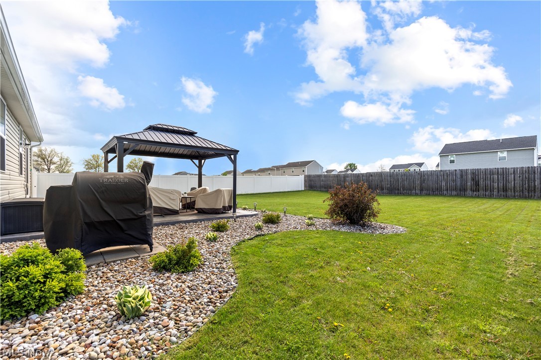 2161 Fowl Road Elyria, OH 44035 - Photo 39 of 46 Spacious backyard featuring a covered patio, a rock garden, and a partial privacy fence