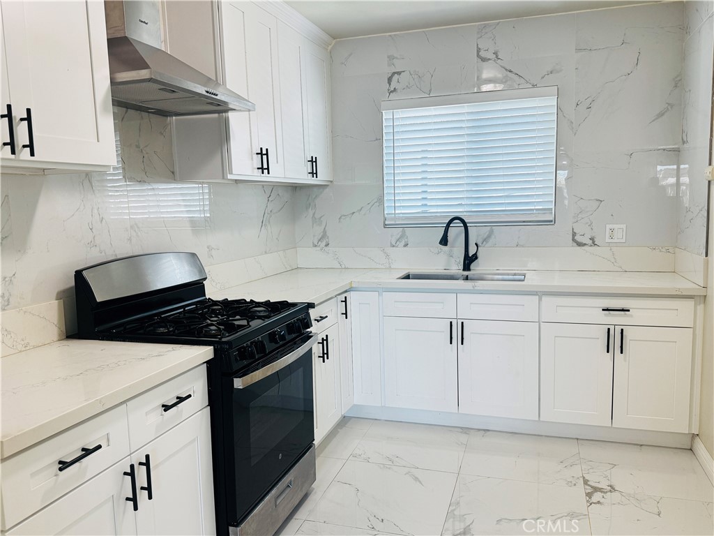 a kitchen with granite countertop white cabinets and white appliances
