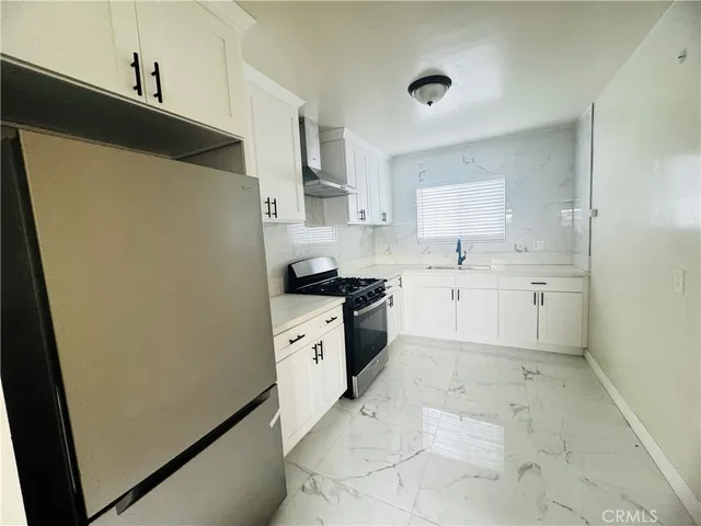 a kitchen with white cabinets and white appliances