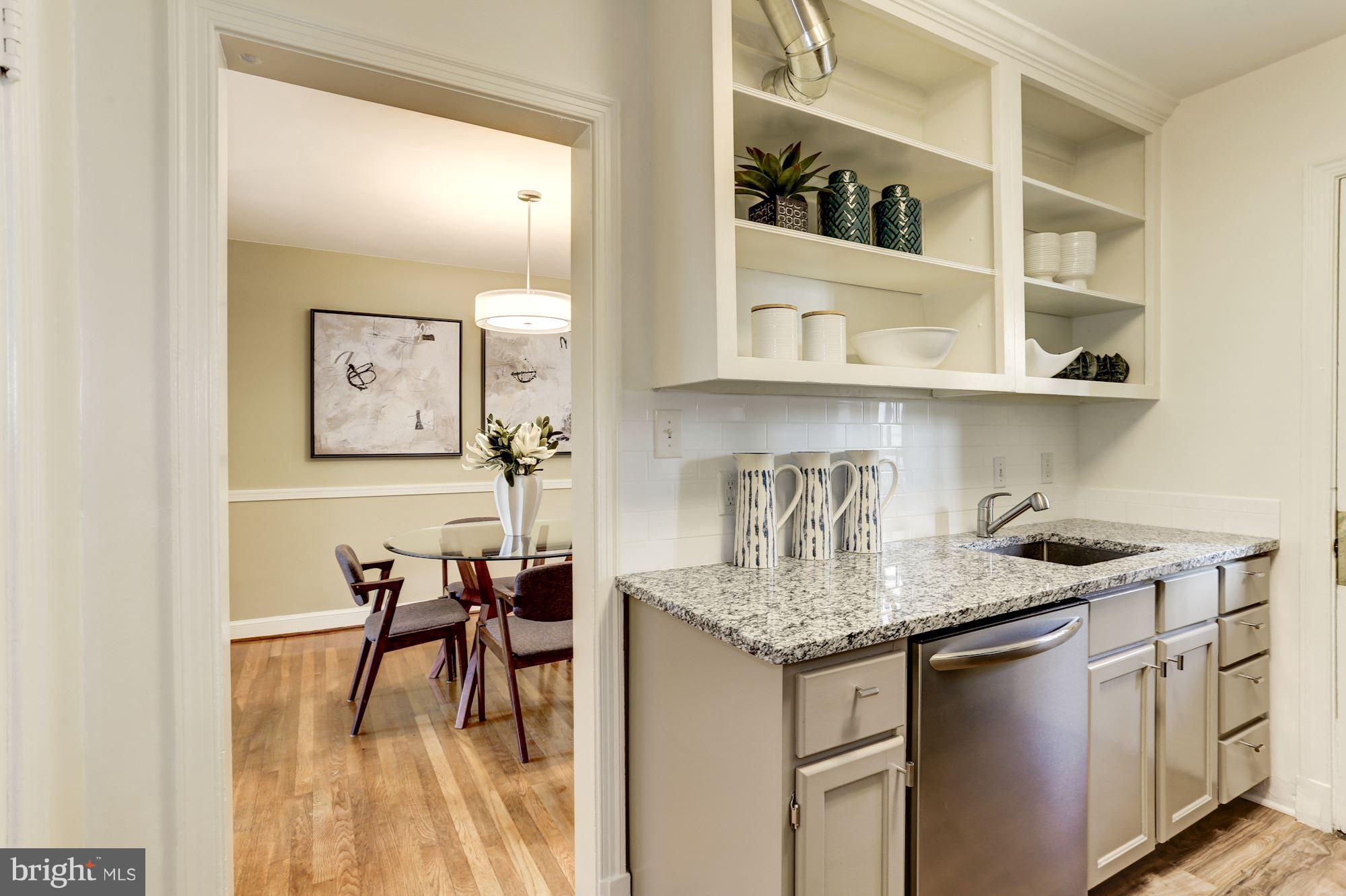 1358 Rittenhouse Street Northwest Washington, DC 20011 - Photo 11 of 30 a kitchen with stainless steel appliances granite countertop a dining table chairs and white cabinets