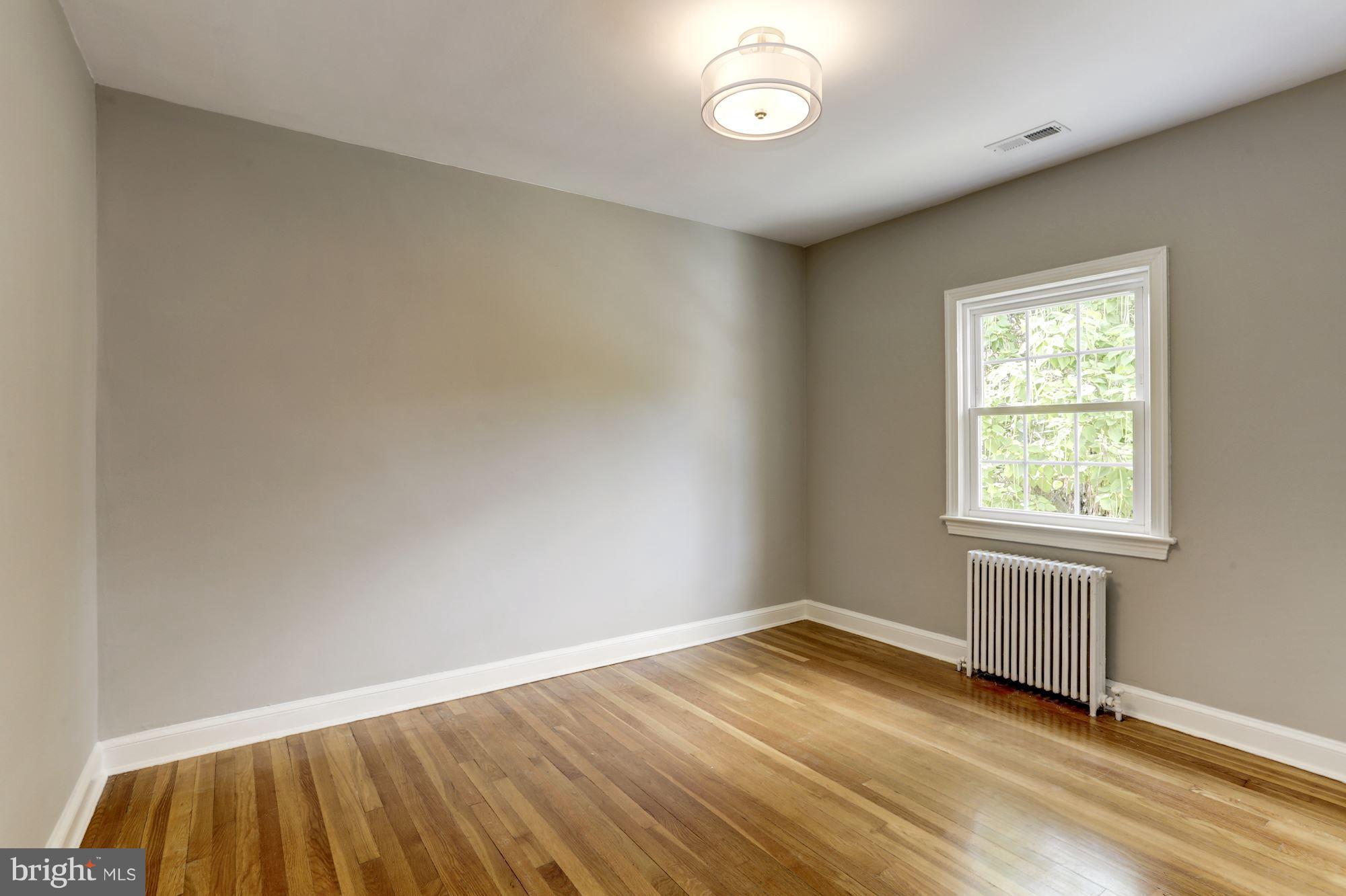 1358 Rittenhouse Street Northwest Washington, DC 20011 - Photo 20 of 30 an empty room with wooden floor and windows