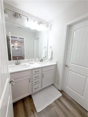 a bathroom with a double vanity sink a mirror and a shower