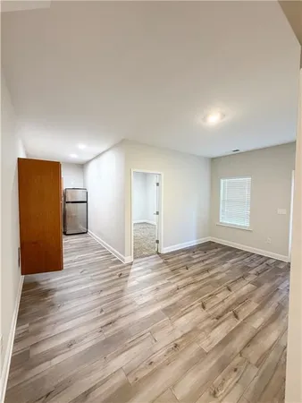 a view of empty room with wooden floor