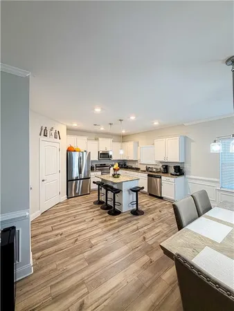 a living room with stainless steel appliances kitchen island granite countertop a stove and a refrigerator