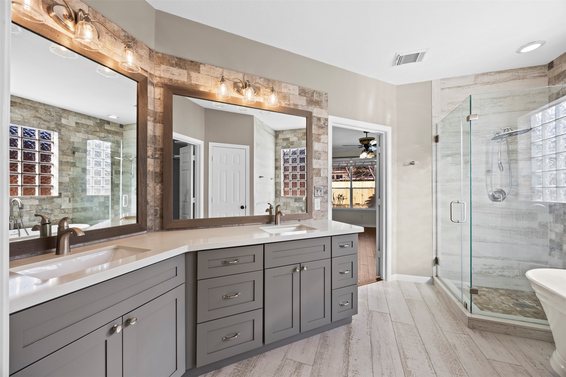 11118 Sprucedale Court Houston, TX 77070 - Photo 18 of 45 a spacious bathroom with a double vanity sink a large mirror a shower and a bathtub