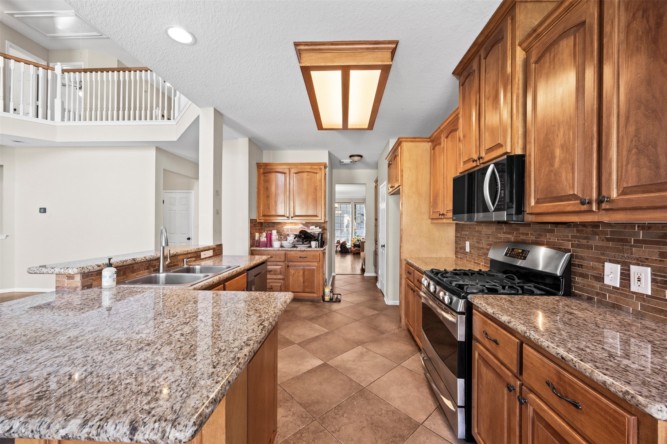 11118 Sprucedale Court Houston, TX 77070 - Photo 8 of 45 a kitchen with granite countertop a sink a stove and cabinets