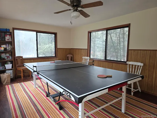 a room with wooden floor pool table and windows