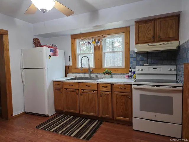 a kitchen with granite countertop a refrigerator stove and sink