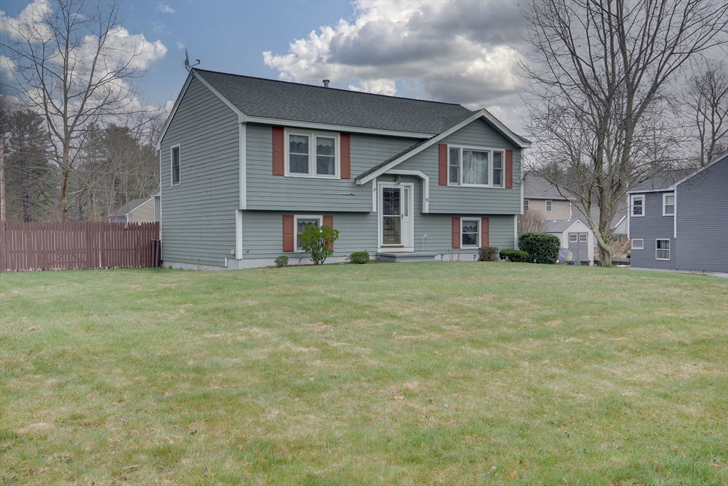 a front view of house with yard and trees around