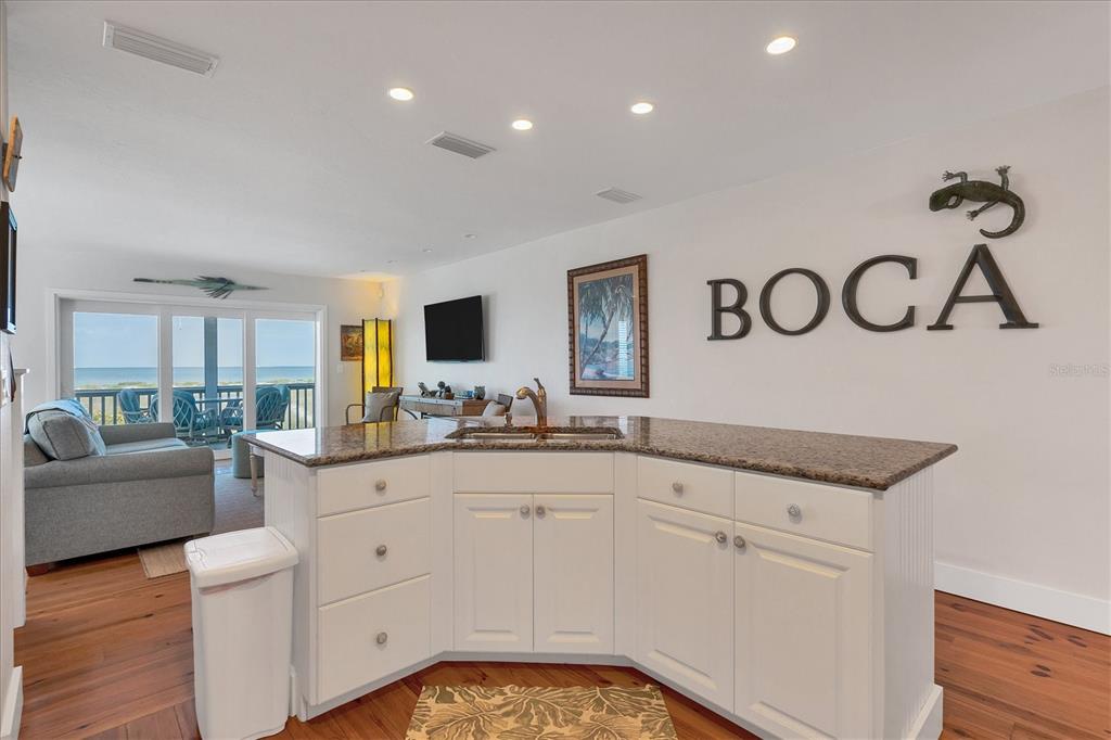 480 Gulf Boulevard, Unit 6 Boca Grande, FL 33921 - Photo 17 of 49 a spacious en suite bathroom with a granite countertop sink and a mirror