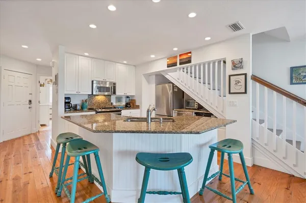 a kitchen with stainless steel appliances kitchen island granite countertop a table and chairs