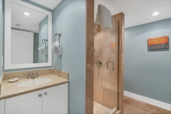 a bathroom with a granite countertop sink shower and a mirror