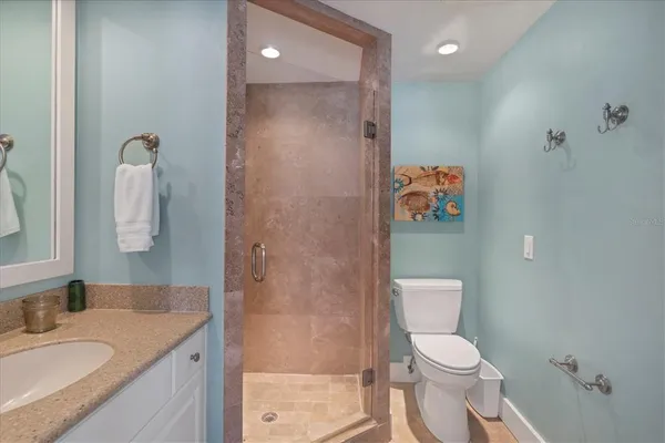 a bathroom with a granite countertop sink a toilet and shower