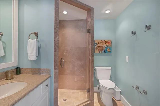 a bathroom with a granite countertop sink a toilet and shower