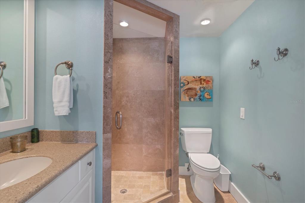 480 Gulf Boulevard, Unit 6 Boca Grande, FL 33921 - Photo 32 of 49 a bathroom with a granite countertop sink a toilet and shower