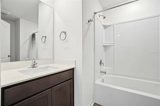 a bathroom with a tub sink shower and mirror