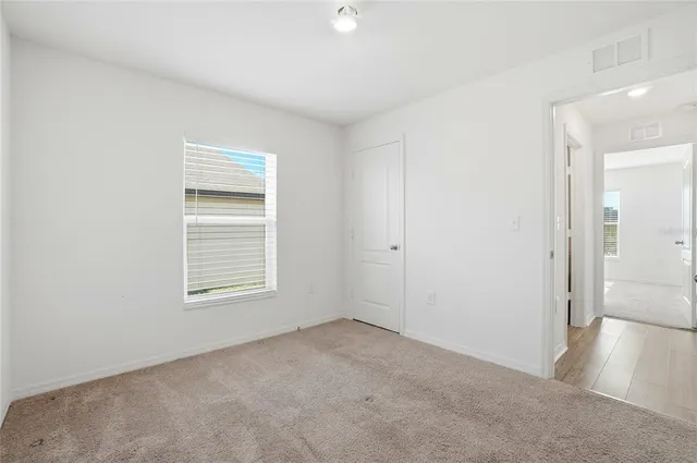an empty room with windows and closet