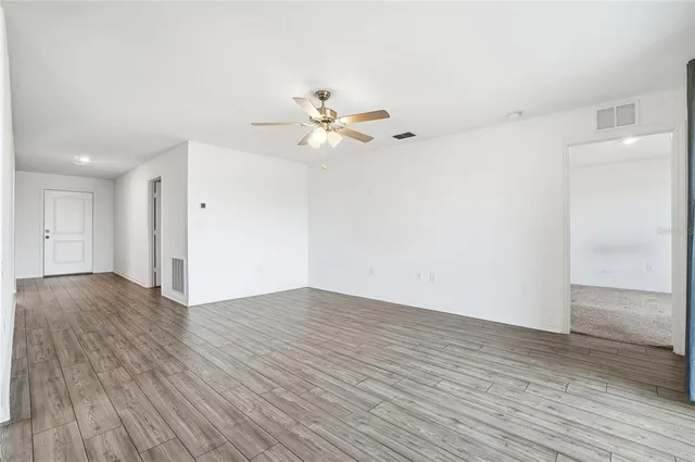 a view of an empty room with wooden floor