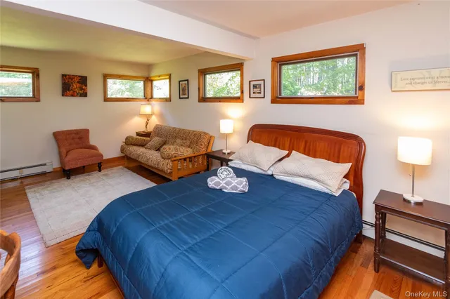 a bedroom with bed couch and window