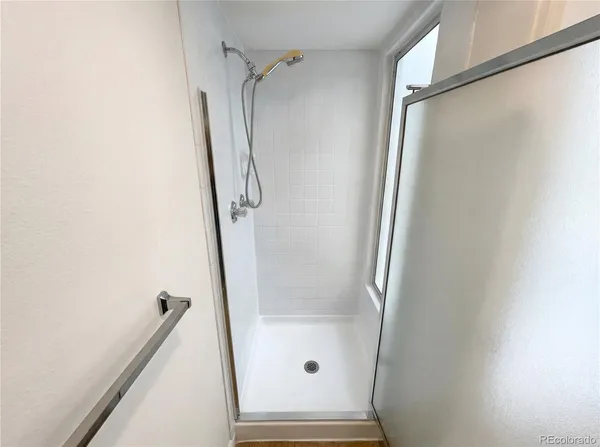 a bathroom with a glass door shower and a sink