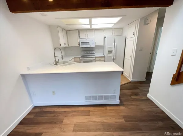 a view of kitchen with cabinets and wooden floor