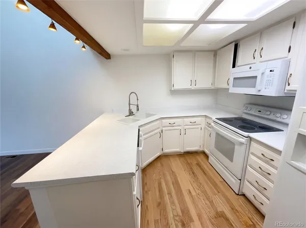 a white kitchen with sink and cabinets