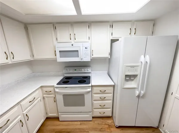 a kitchen with refrigerator a stove a microwave and cabinets