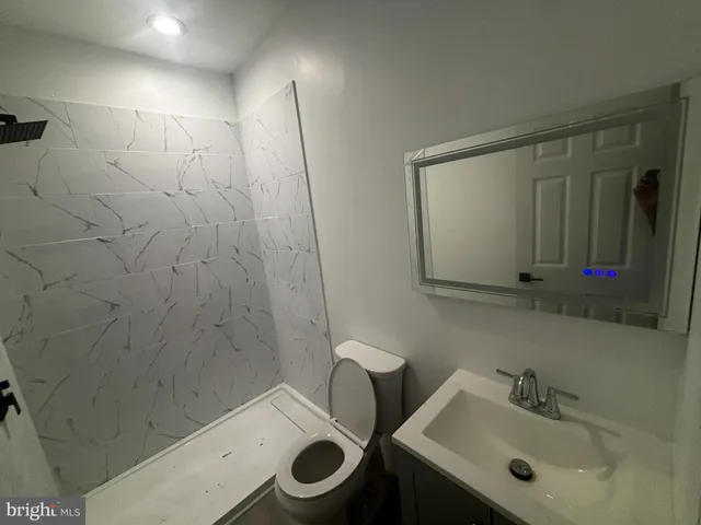 a bathroom with a sink mirror and toilet