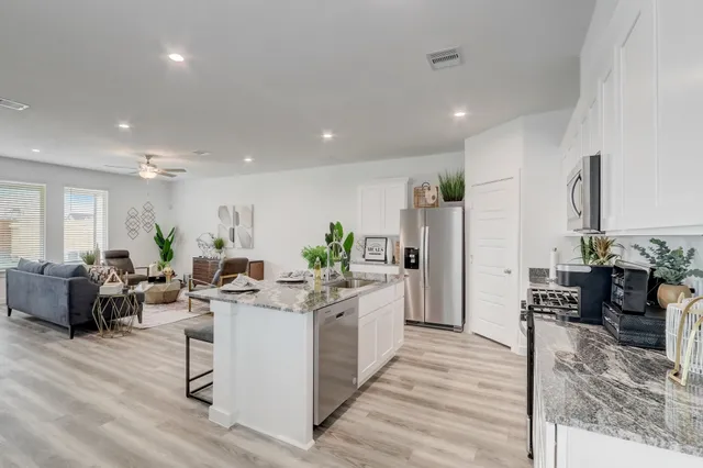 a view of a living room kitchen and a wooden floor