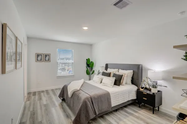a bedroom with a bed and wooden floor