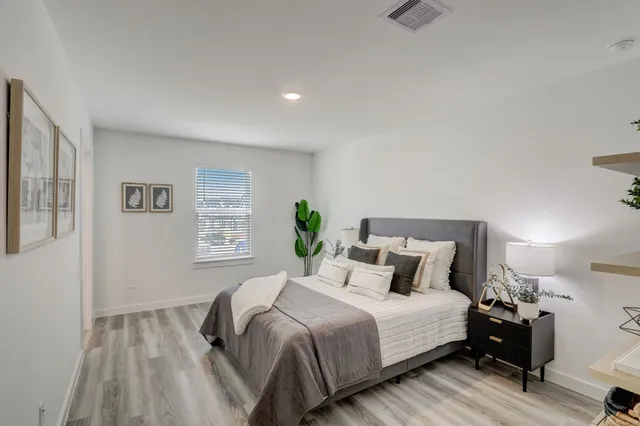 a bedroom with a bed and wooden floor