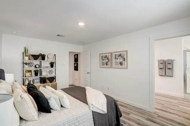 a bedroom with a bed and a wooden floor