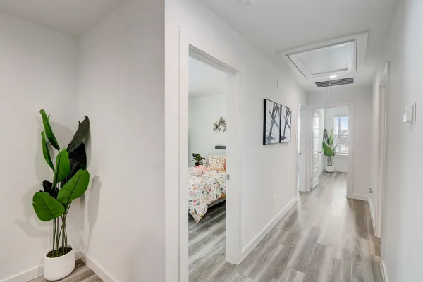 a view of a hallway to a livingroom with wooden floor