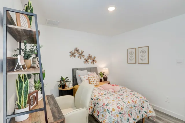 a bedroom with a bed and a painting on the wall