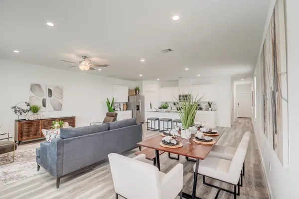 a living room with furniture and a dining table with wooden floor