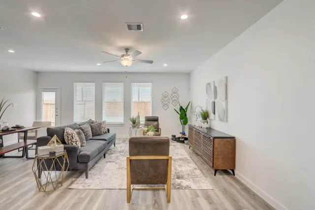 a living room with furniture and wooden floor