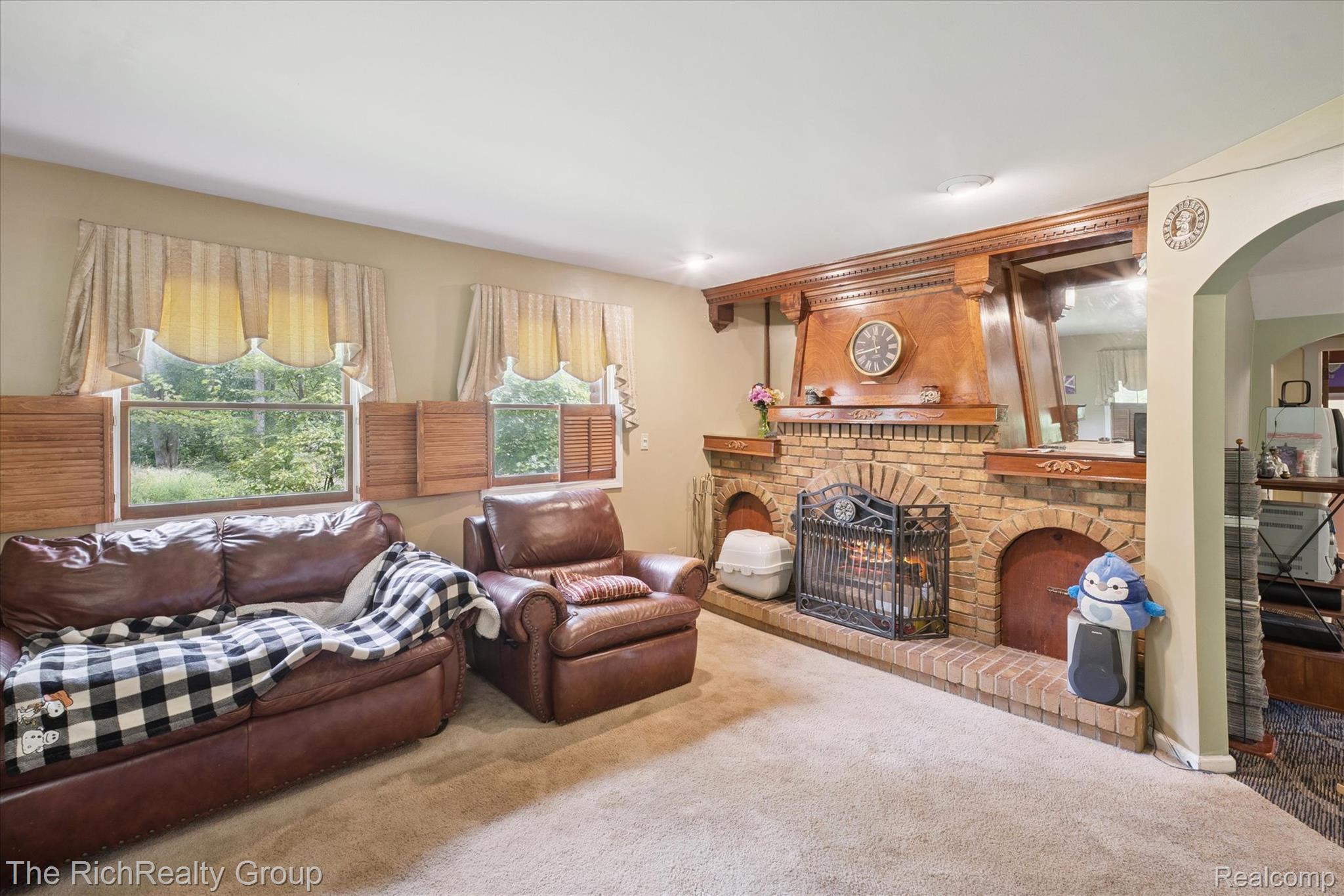 39635 Lotzford Road Canton, MI 48187 - Photo 16 of 39 Living room featuring carpet floors, a brick fireplace, and arched walkways