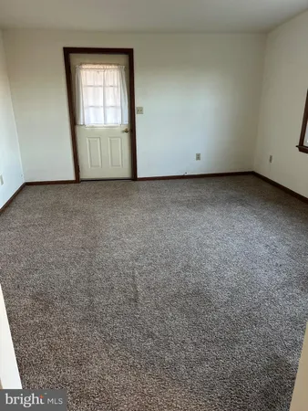 a view of an empty room with wooden floor and closet