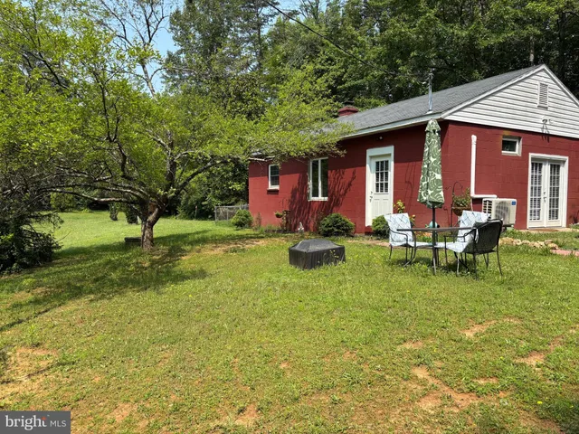 a view of a house with backyard and sitting area