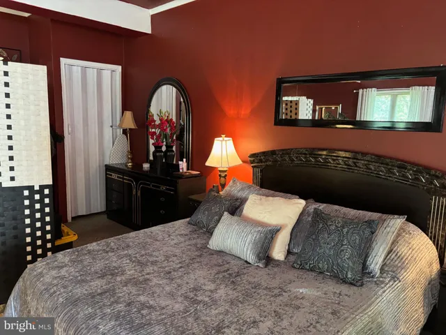 a bedroom with a bed and dresser with mirror