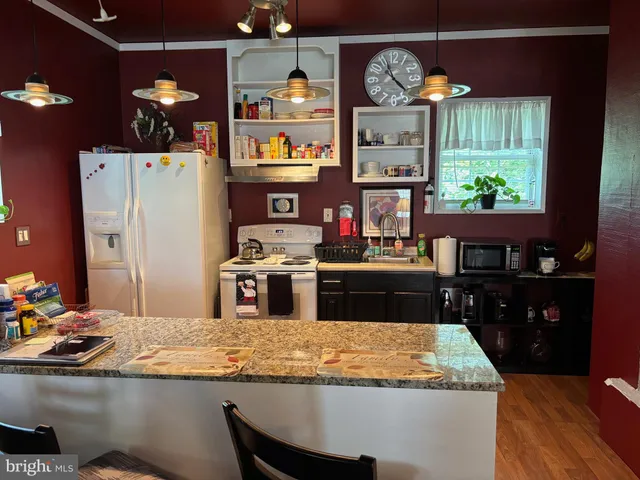 a kitchen with kitchen island granite countertop a sink stainless steel appliances and a counter top space
