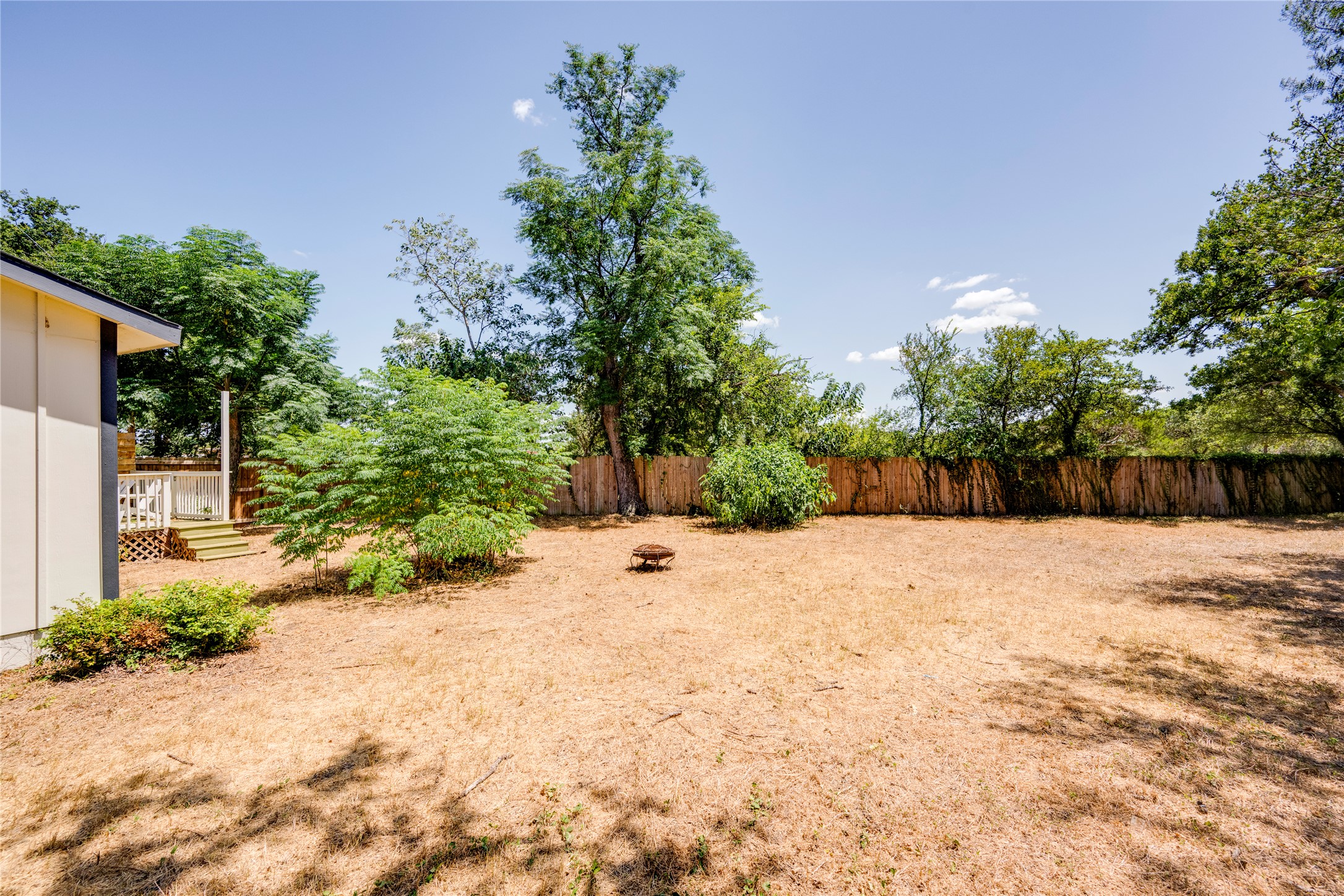 1400 Marcus Place, Unit B Austin, TX 78721 - Photo 38 of 39 A spacious yard with mature trees and privacy fencing, perfect for outdoor activities.