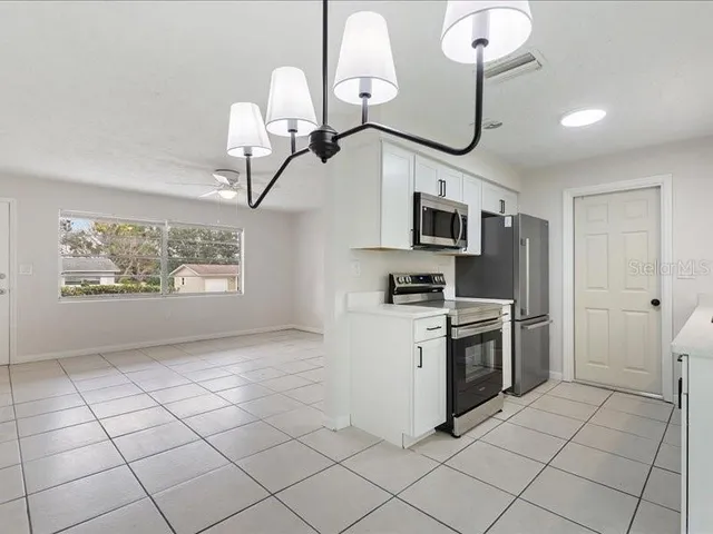 a kitchen with granite countertop a sink a stove top oven and stainless steel appliances