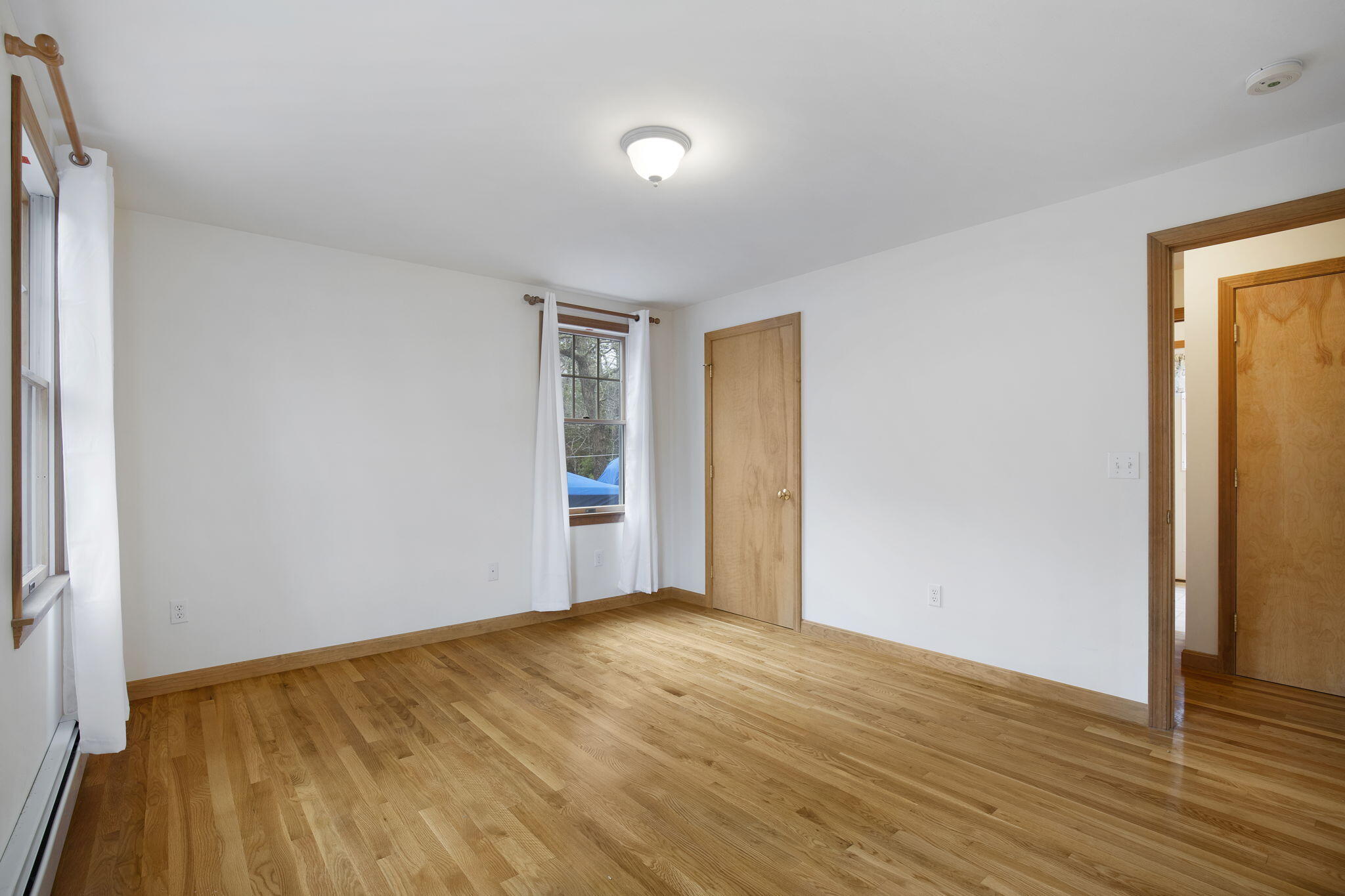 65 Whitney Road Eastham, MA 02642 - Photo 23 of 41 a view of an empty room with wooden floor and a window