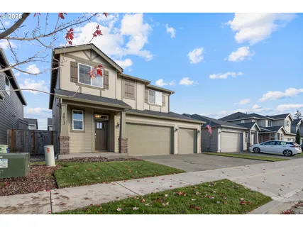 a view of a white house with large windows and a small yard