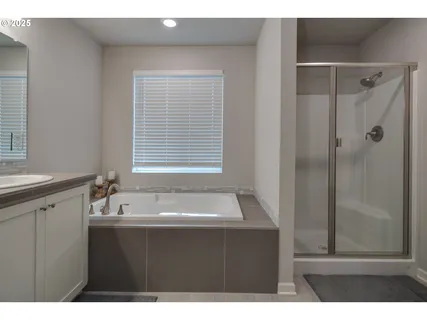 a bedroom with a bed and a flat tv screen on dresser