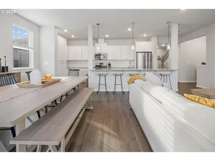 a large white kitchen with kitchen island a stove a sink a refrigerator and white cabinets
