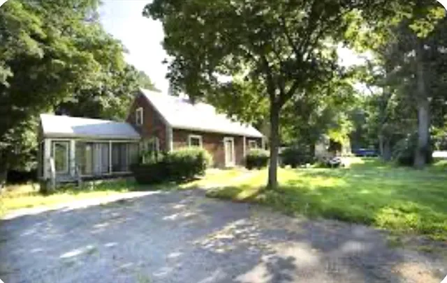 a view of a house with yard and sitting area