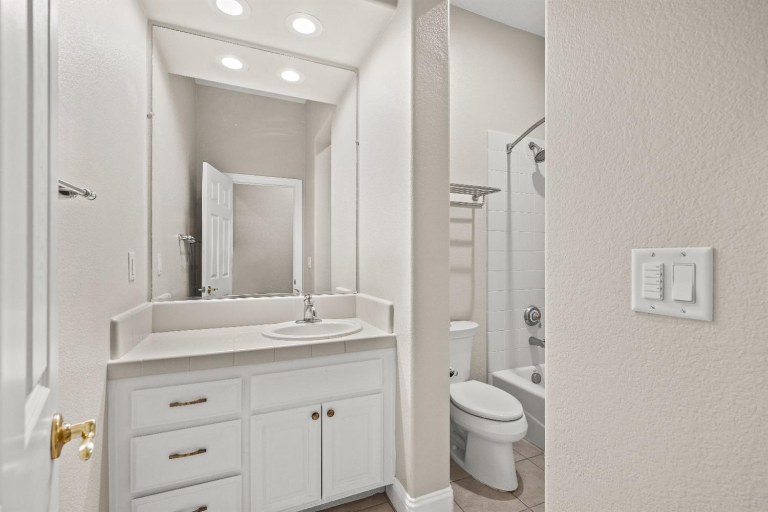 18040 Ruddy Street Woodland, CA 95695 - Photo 24 of 40 a bathroom with a granite countertop sink toilet a large mirror and shower