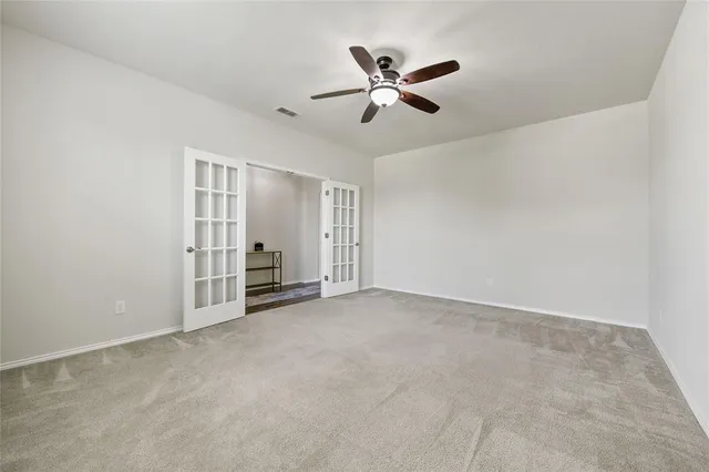 a view of empty room with ceiling fan